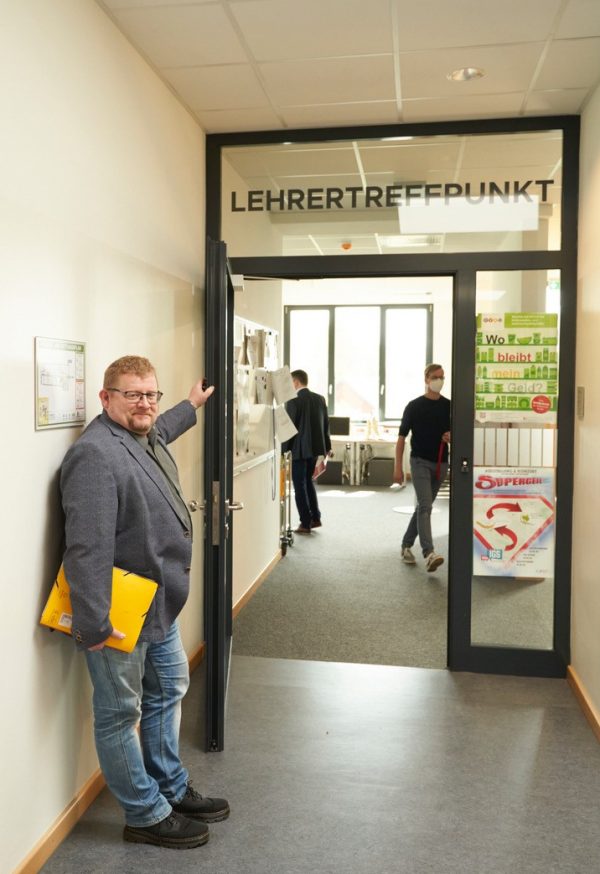 Bernd Wölbern, der von Beruf selbst Lehrer ist, hält die Tür zum Lehrertreffpunkt auf.